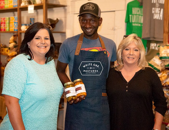 Chad poses with LeAnns founders when they visited White Oak Pastures Chad sourced their product for the General Store