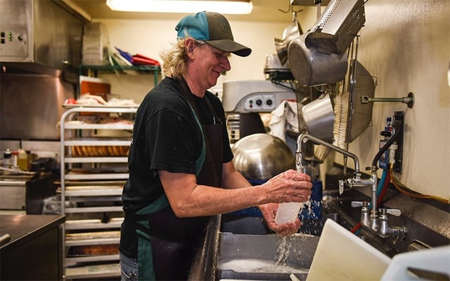 Cecil washing dishes at the farm to table dining pavillon at White Oak Pastures