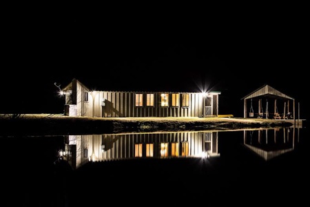 Pond house reflecting on the water at night