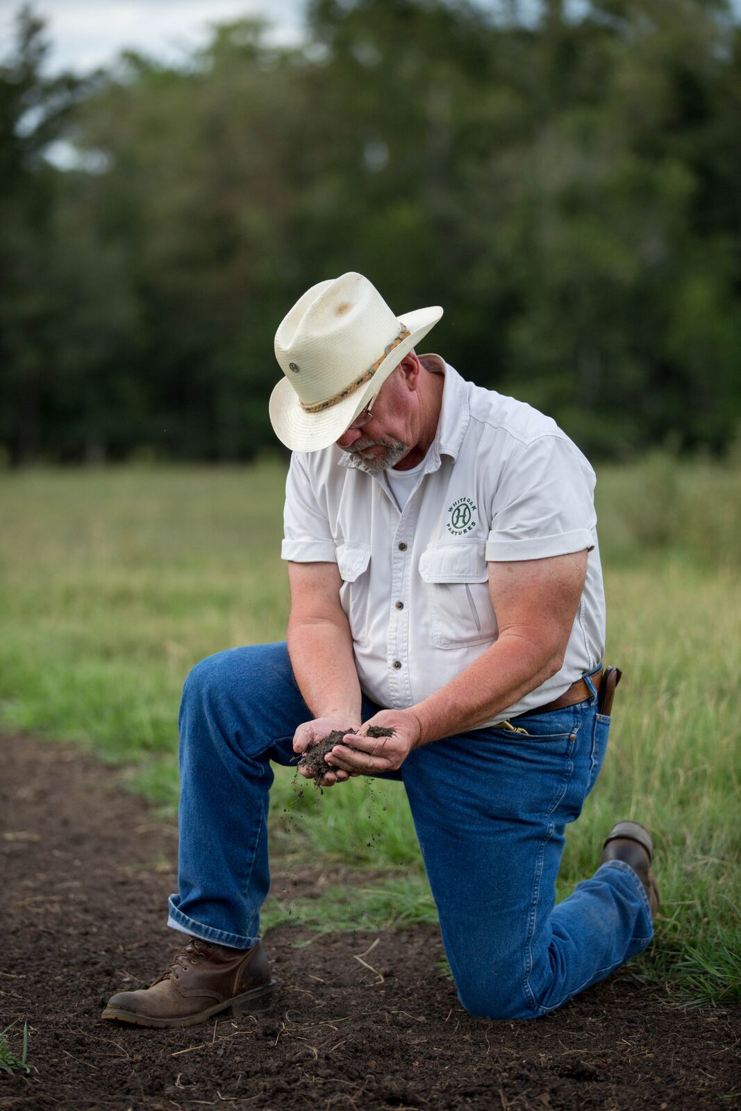 Will Harris examines the soil at White Oak Pastures